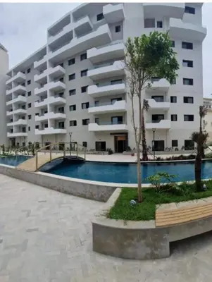 a large apartment building with a pool in front of it at Beautiful apartment in the heart of Zenata in Aïn Harrouda