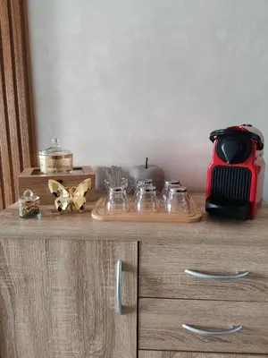a wooden cabinet with a tray of glass dishes on it at Beautiful apartment in the heart of Zenata in Aïn Harrouda