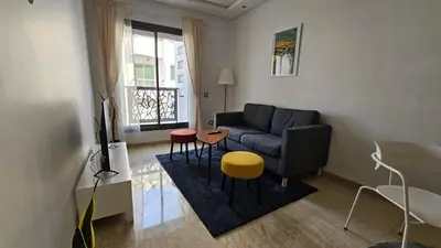 a living room with a couch and a table and stool at Apartment with terrace - Strategic location in Casablanca
