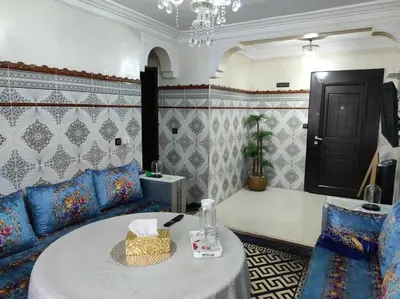 a living room with a blue couch and a table at Charming Moroccan apartment ground floor 2 bedrooms 1 living room in Casablanca