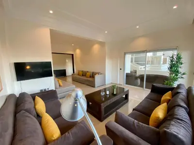 a large living room with a couch and a tv at Appartement Vue Panoramique sur la siesta plage WELCOME STAY in Mohammedia