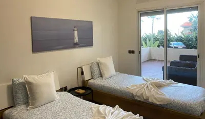 a bedroom with two beds with a lighthouse on the wall at Appartement Vue Panoramique sur la siesta plage WELCOME STAY in Mohammedia