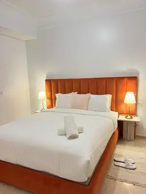 a bedroom with a large white bed with two lamps at Sunshine Apartment in Casablanca