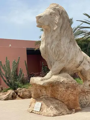 a statue of a lion sitting on a rock at Logement cozy in Oulad Kerroum
