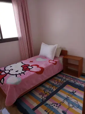 a bedroom with a bed with a hello kitty blanket at Logement cozy in Oulad Kerroum