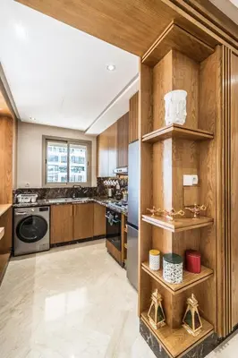 a kitchen with wooden cabinets and a refrigerator at Contemporary apartment in CFC Anfa in Casablanca