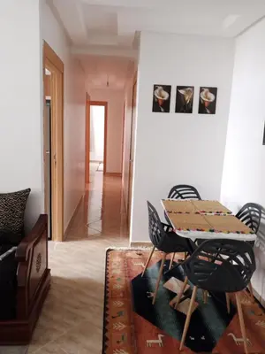 a room with a table and chairs and a hallway at Luxurious space in Oulad Kerroum