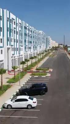 two cars parked in a parking lot next to a building at Luxurious space in Oulad Kerroum