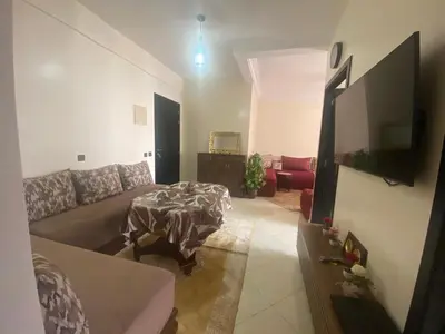 a living room with a couch and a flat screen tv at Appartement confortable et ensoleillée in Aïn Harrouda