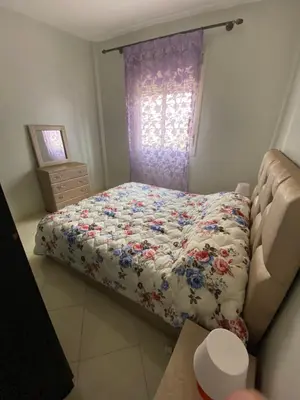 a small bedroom with a bed and a window at Appartement confortable et ensoleillée in Aïn Harrouda