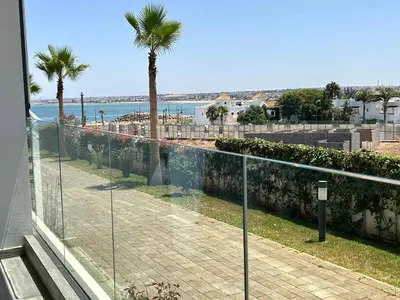 a balcony with a view of the ocean and a palm tree at Condo beach view in Casablanca in Casablanca