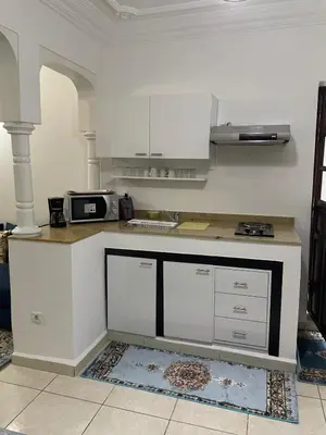 a kitchen with white cabinets and a counter top at Un petit studio in Settat