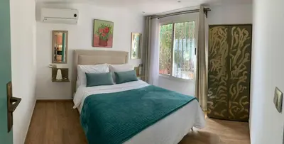 a bedroom with a bed with blue pillows and a window at Palmeraie 3 in Skhirat