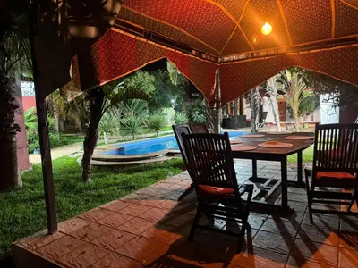 a table and chairs under an umbrella on a patio at Villa luxueuse à Skhirat Rabat in Skhirat