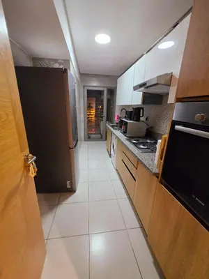a kitchen with a black refrigerator and a white tile floor at Luxe & Confort in Cité de Bournazel