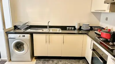 a kitchen with a sink and a washing machine at N42 Luxe et Élégance avec Jacuzzi Privatif sur la Corniche Rabat Essabah in Rabat