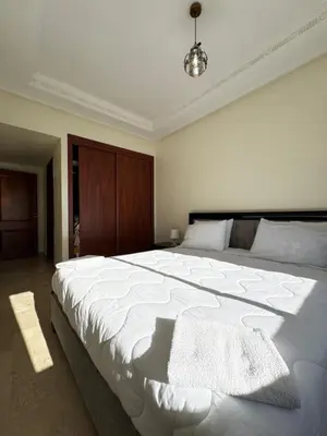 a bedroom with a large white bed in a room at SUITOUISS - AGDAL 5 - Appartements à 2 minutes de la gare de train TGV Rabat in Rabat