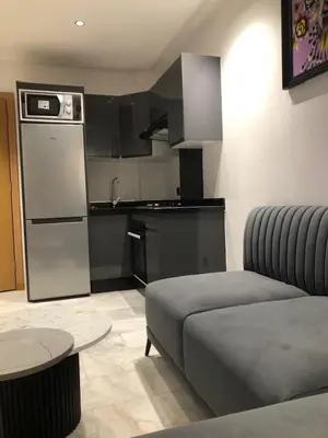 a living room with a couch and a kitchen at AbboGroup APPARTEMENT in Casablanca
