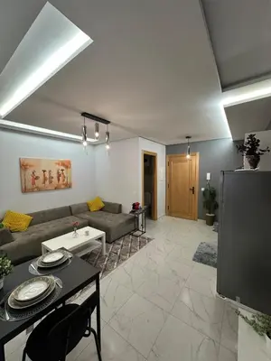 a living room with a couch and a tv at Stylish Cozy Condo Downtown City Center Casablanca in Casablanca