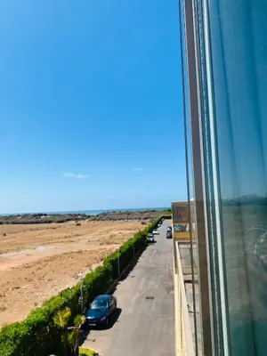 a view of a road from a window of a building at Sidi rahal blue beach Cozy apartment with a sea view in Sidi Rahal