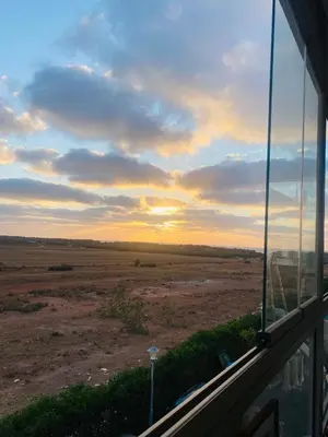 a view of a field from the window of a house at Sidi rahal blue beach Cozy apartment with a sea view in Sidi Rahal