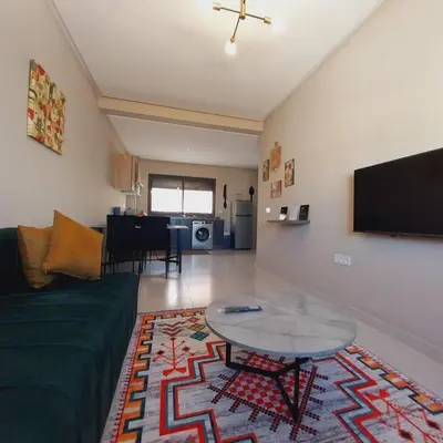 a living room with a green couch and a table at Family airport relax apartment in Deroua
