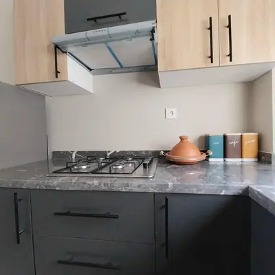 a kitchen with a stove and a counter top at Family airport relax apartment in Deroua