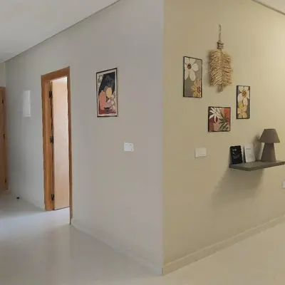 a room with a white wall with pictures on it at Family airport relax apartment in Deroua