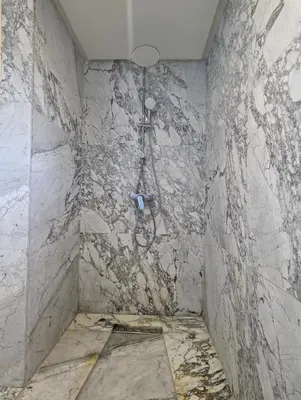 a shower in a bathroom with a marble wall at Seafront Luxury Villa with Amazing pool! in Dar Bouazza