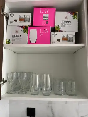 a shelf with wine glasses and boxes on it at ZS house harhoura in El Harhoura
