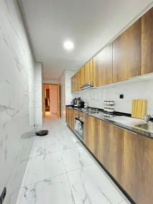 a kitchen with white marble floors and wooden cabinets at ZS house harhoura in El Harhoura