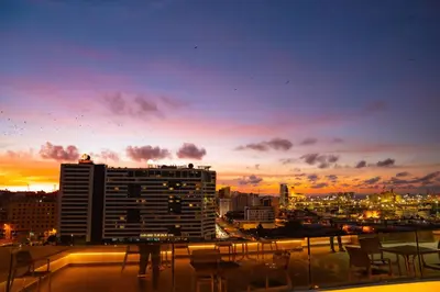 a view of a city at sunset from a balcony at R104- Luxurious Penthouse with Incredible Sea View in Casablanca