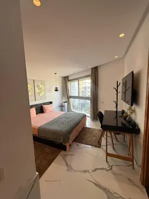 a bedroom with a bed and a desk and a window at Stunning sea-view apartment 20 in Casablanca