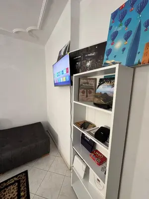 a small room with a refrigerator and a bed at Appartement Dadi in Rabat