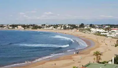 a view of a beach with people on it at Neuf 3min de la plage au parc avec parking in Mohammedia
