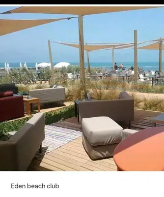 an image of a beach with chairs and an umbrella at Nid Douillet Bouznika A7mn de la playa in Bouznika