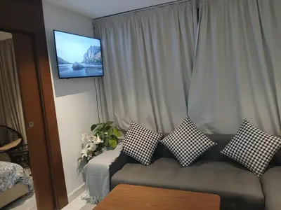 a living room with a couch with pillows and a tv at Triangle des hôtels in Casablanca