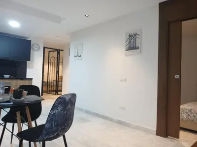 a living room with a table and chairs and a bedroom at Triangle des hôtels in Casablanca
