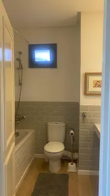 a bathroom with a toilet and a tub and a window at Spacious Apartment In CIL Casablanca in Casablanca