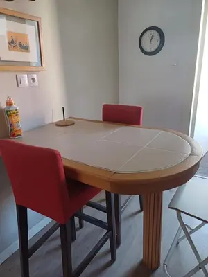 a dining room table with two chairs and a clock on the wall at Spacious Apartment In CIL Casablanca in Casablanca
