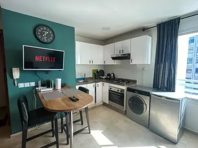a kitchen with a wooden table and a kitchen with a sink at Central and Practical Studio - Boulevard d'Anfa in Casablanca