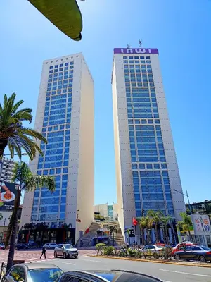 two tall buildings with palm trees in front of a street at Luxury apartment in a prime location and quiet in Casablanca