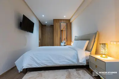 a bedroom with a bed and a tv on a wall at Acacia Studios in Casablanca