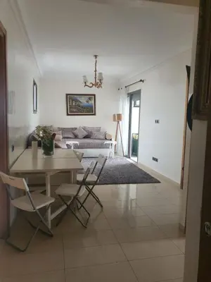 a living room with a table and chairs and a couch at apart Blanca beach sur mer in Sidi Rahal
