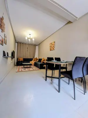 a living room with a table and chairs and a couch at Green Haven Near Airport Stay in Deroua