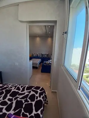 a bedroom with a cow print bed and a window at Appartement Lumineux Front de Mer à CASABLANCA in Casablanca