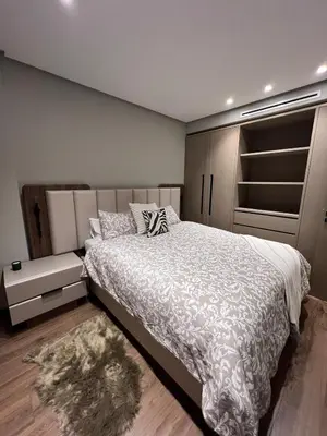 a bedroom with a bed with a white comforter at Appartement à Casablanca Ferme bretonne OCP à 5min du CFC in Casablanca