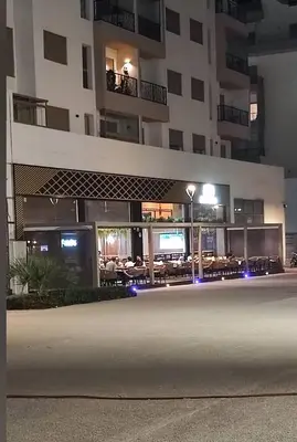 a building with tables in front of it at night at Luxury & sweet studio apartment with swimming pool in Aïn Harrouda