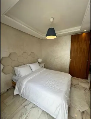 a bedroom with a large white bed and a blue light at Résidence Saphir Luxury apartment with terrace in Racine in Casablanca