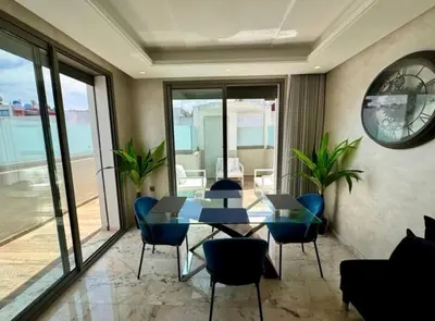 a dining room with a table and chairs and a clock at Résidence Saphir Luxury apartment with terrace in Racine in Casablanca
